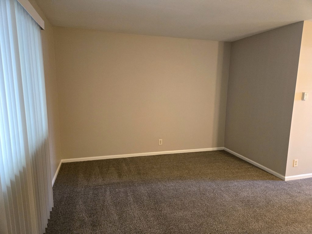 a empty room with carpet and a curtain