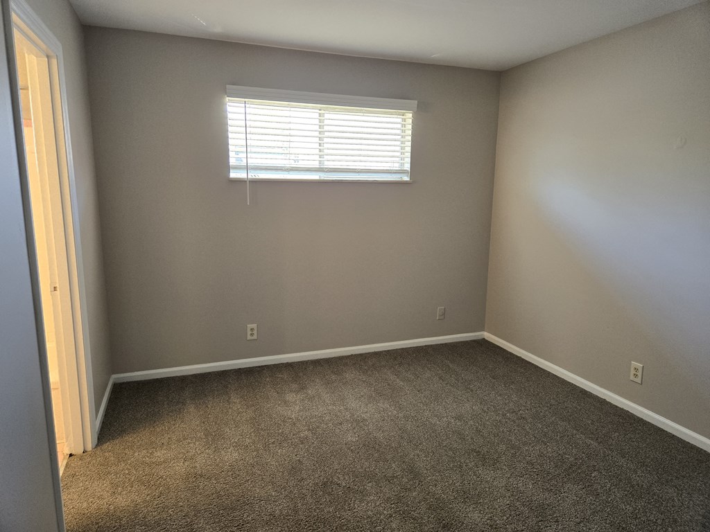 an empty room with carpet and a window