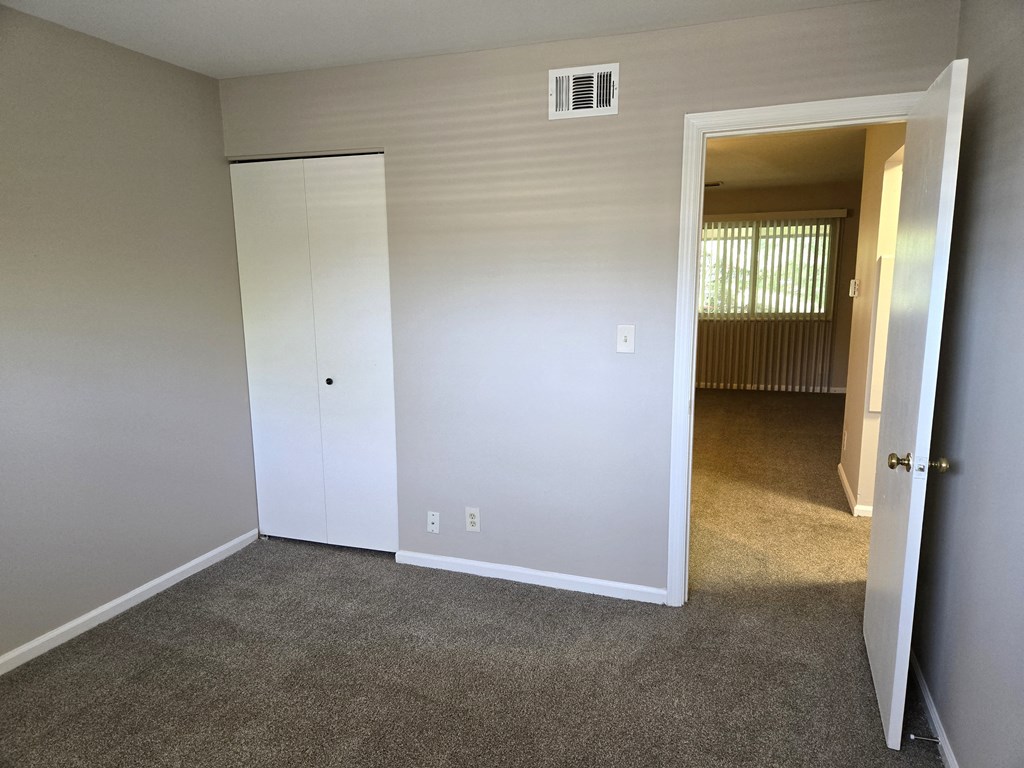 a bedroom with a closet and an open door