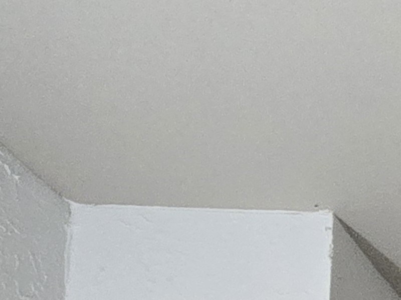 an empty room with a white wall and a staircase