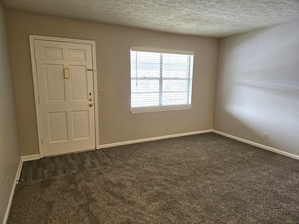 an empty room with a door and a window