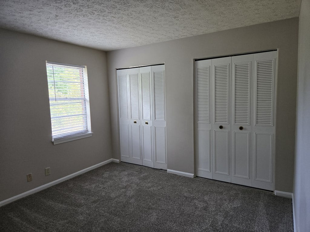 a bedroom with two closets and a window