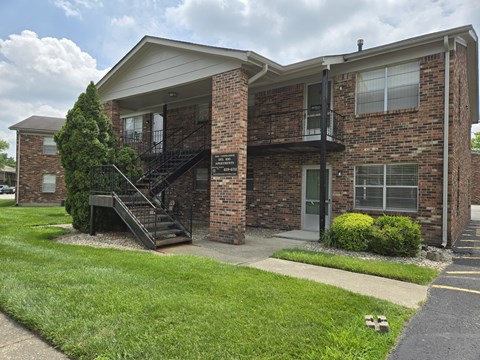 A brick apartment building with a black metal staircase.