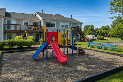 A playground with a red, yellow and blue slide.