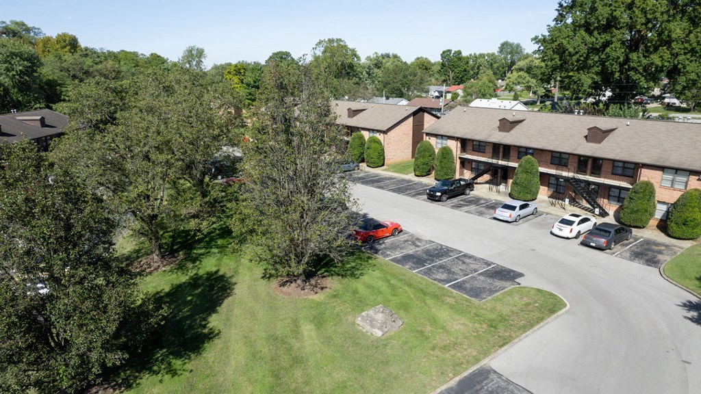an aerial view of a hotel and parking lot with trees