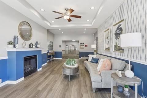 A living room with a grey couch and a blue fireplace.