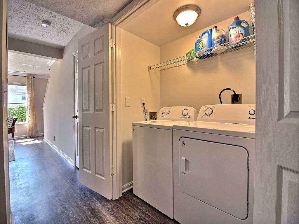 a laundry room with a washer and dryer and a door into a hallway