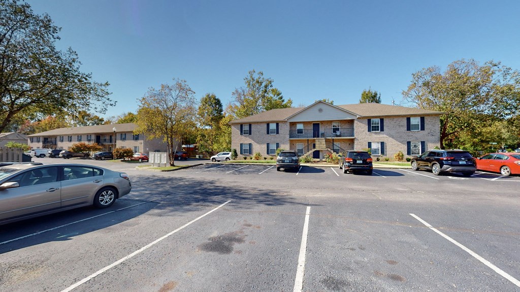 an empty parking lot in front of an apartment building