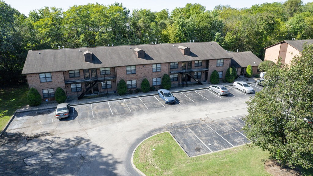 an aerial view of an apartment building with cars parked in front of it