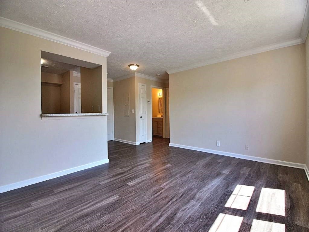 an empty living room with wood floors and white walls
