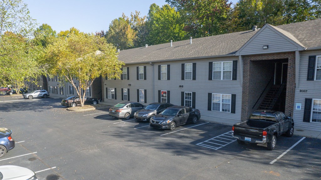 a large apartment building with cars parked in front of it