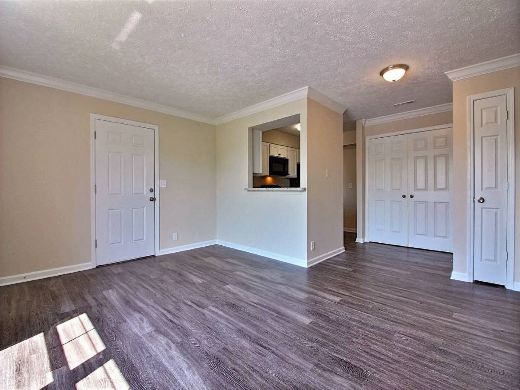 an empty living room with a hard wood floor