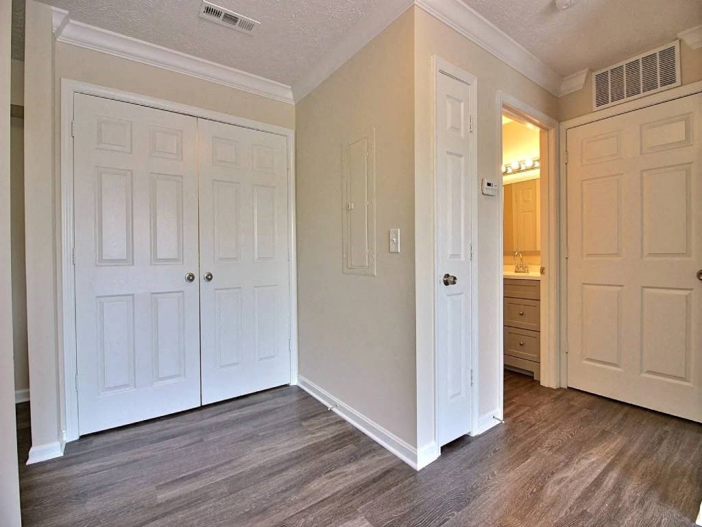 an empty bedroom with white doors and a bathroom