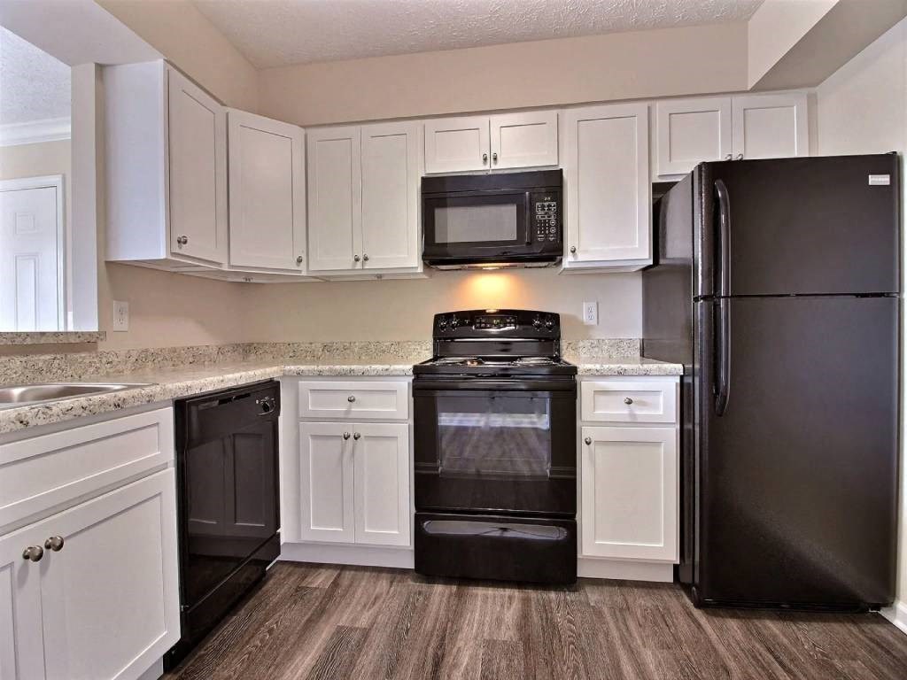 a kitchen with black appliances and white cabinets