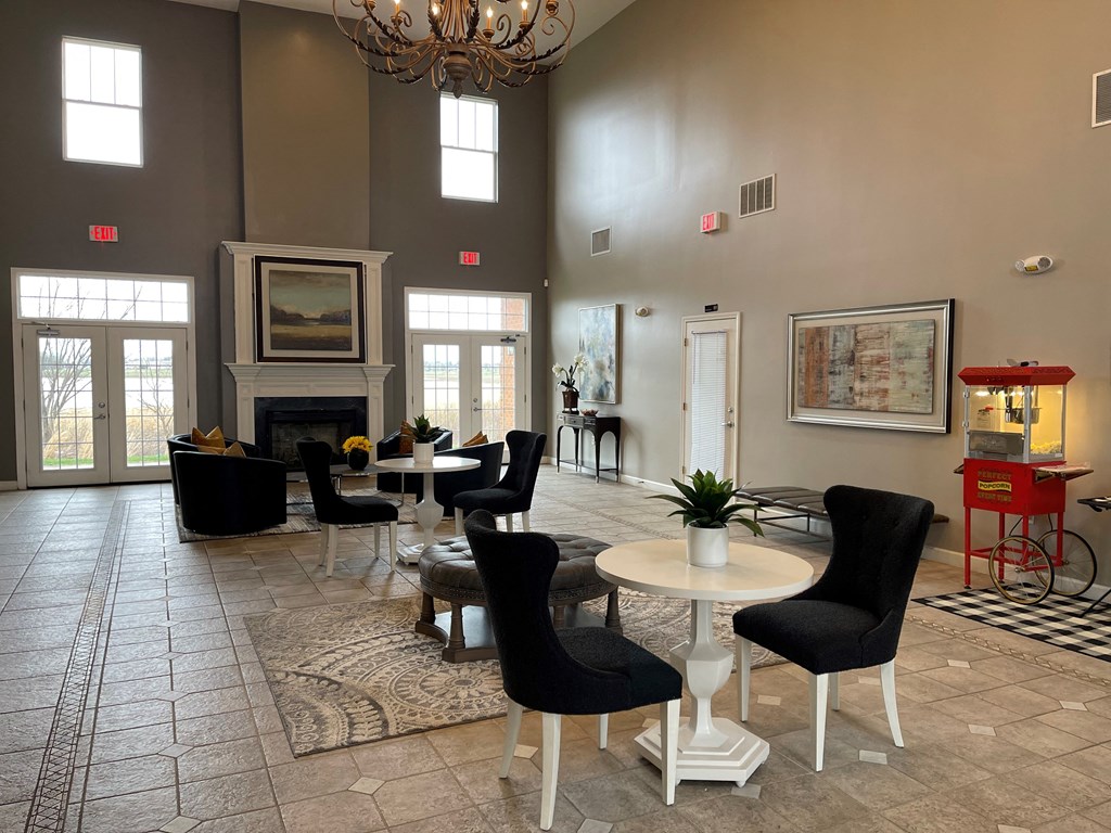 a lobby with tables and chairs and a fireplace