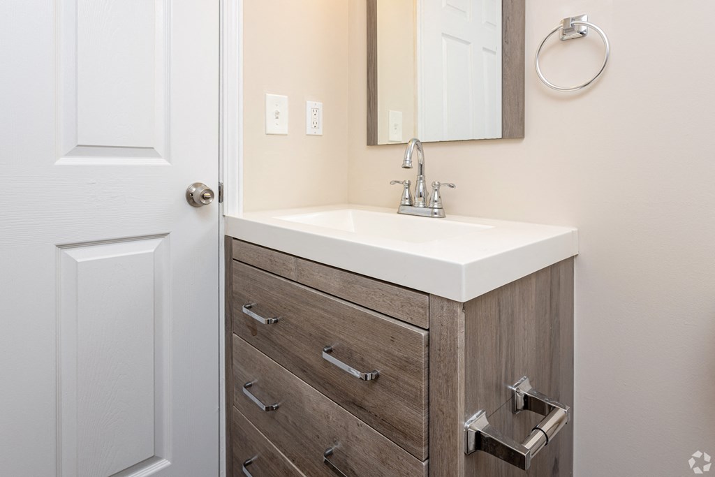 a bathroom with a sink and a mirror and a door