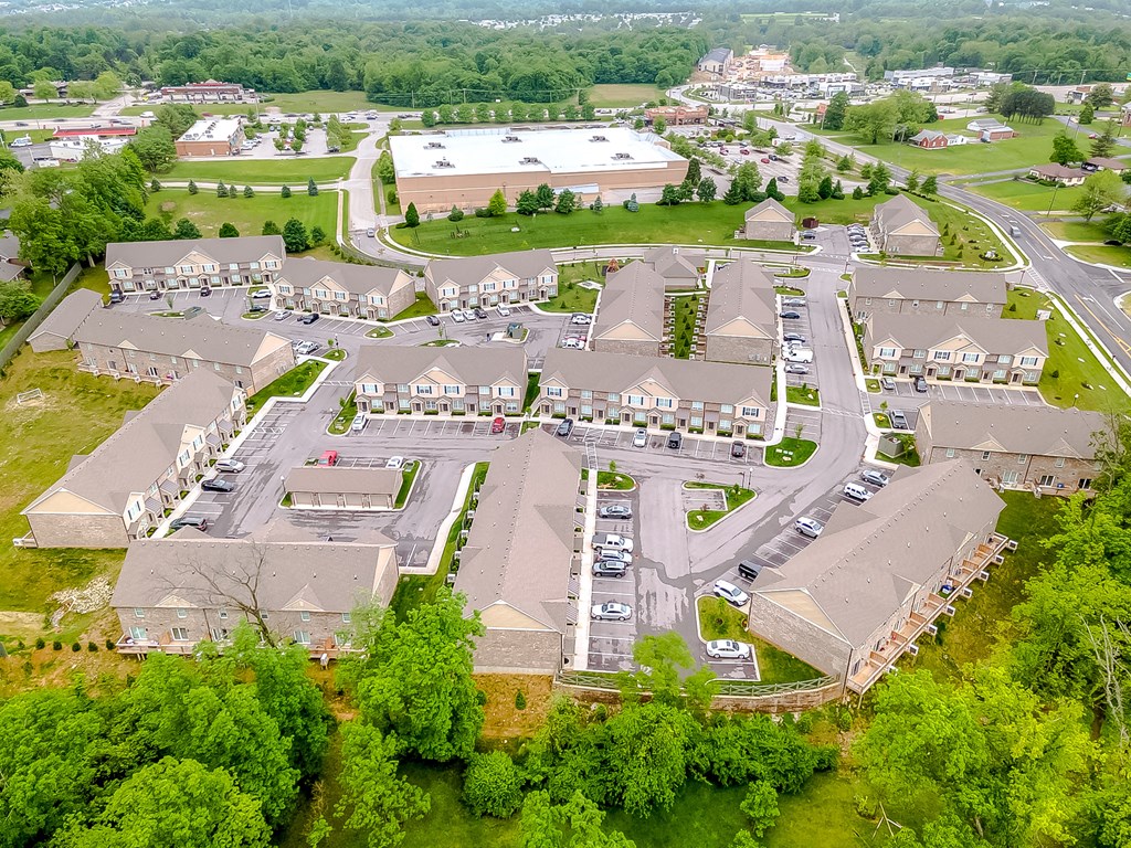 an aerial view of a neighborhood of houses with cars parked in a parking lot