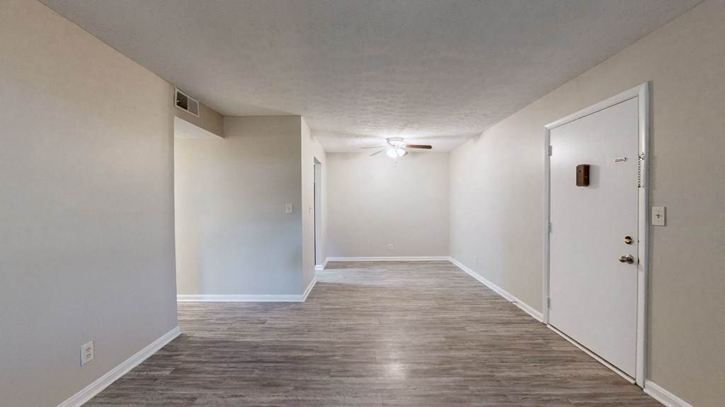 a hallway with white walls and a tile floor and a door