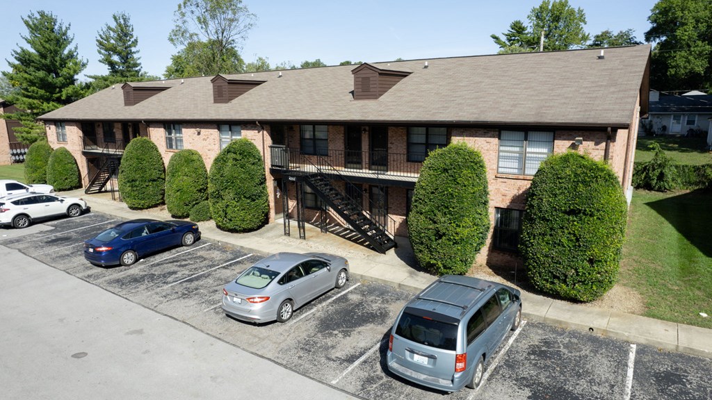 an aerial view of a house with cars parked in a parking lot