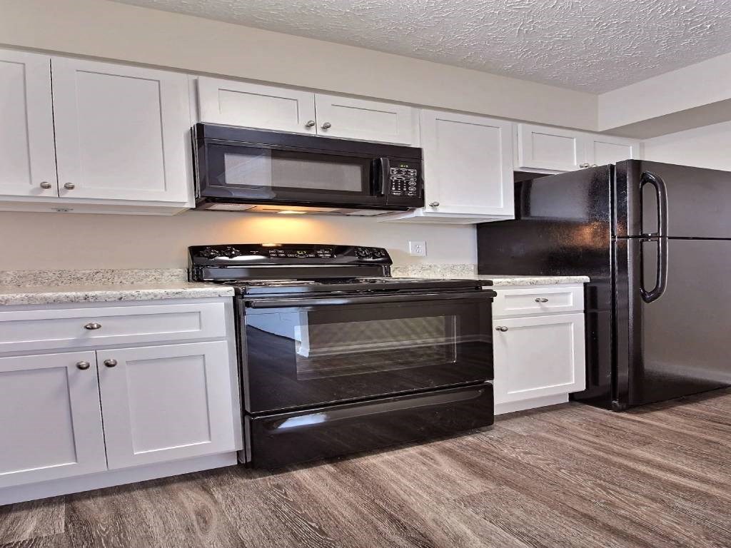 a kitchen with black appliances and white cabinets
