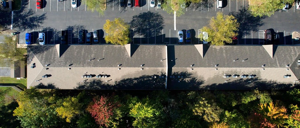 an aerial view of a parking lot with cars and trees