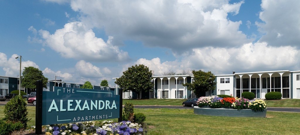 A sign for The Alexandra Apartments is in front of a building.