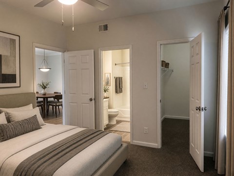 A bedroom with a bed, dresser, and mirror.