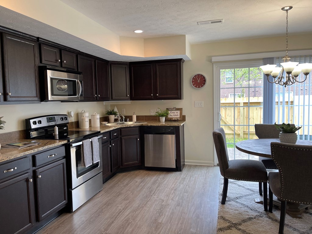 a kitchen with stainless steel appliances and a table with chairs