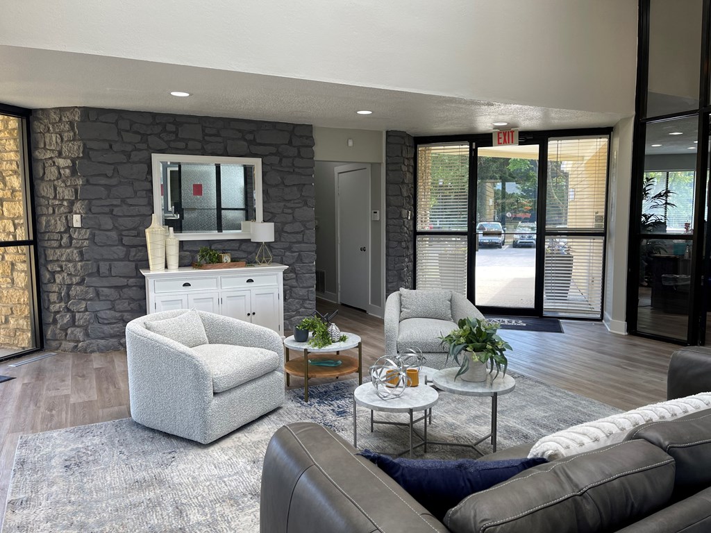 a living room with a stone wall and couches and chairs
