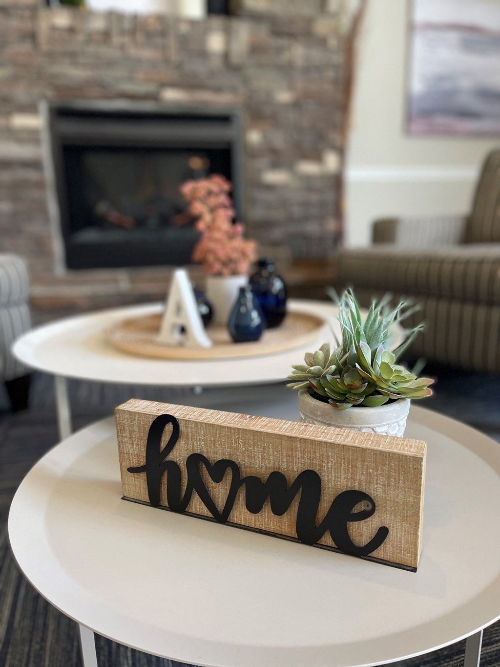 a living room with a coffee table with a wooden block that says home on it