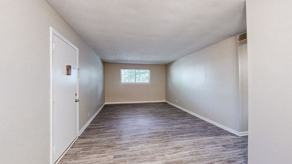 an empty room with white walls and a window