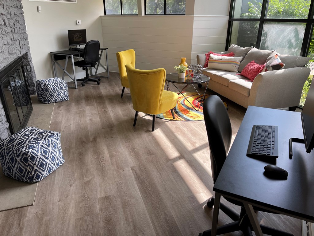 a living room with a couch and a desk with a laptop