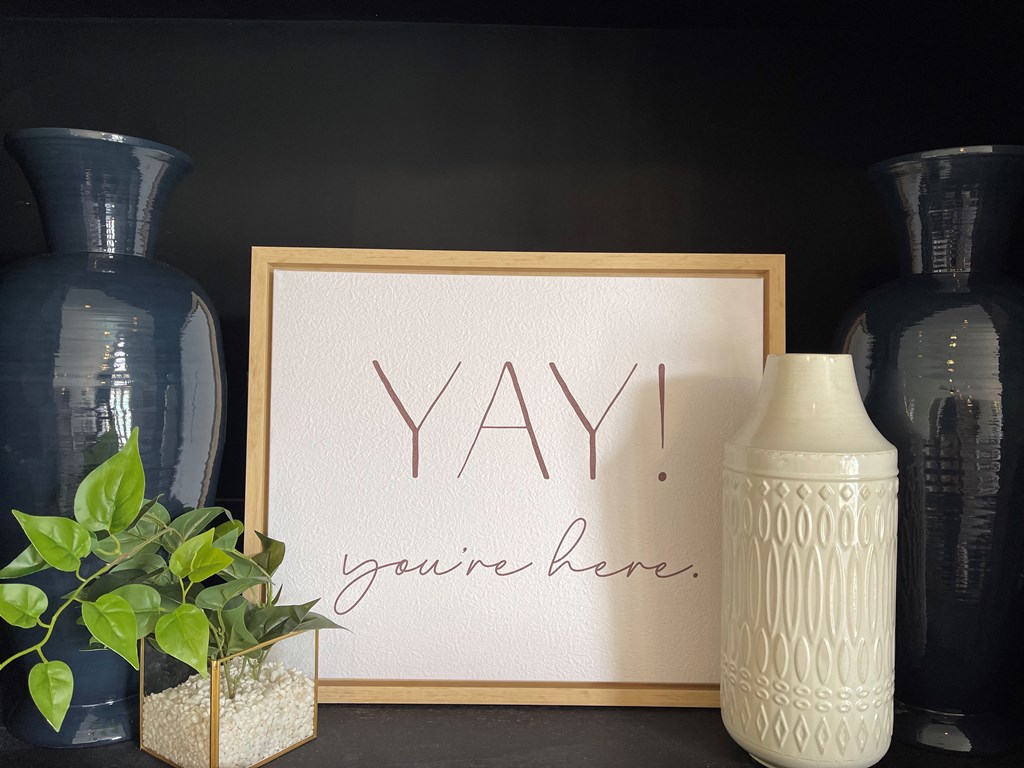 a table with vases and a sign that reads yay you are here