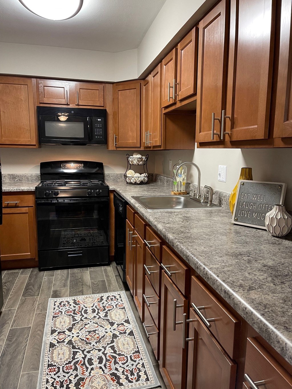 a kitchen with wood cabinets and granite counter tops and black appliances