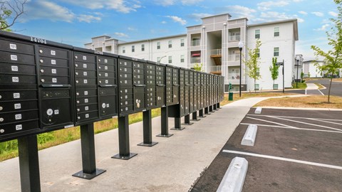 a row of mailboxes on a street with a building in the background