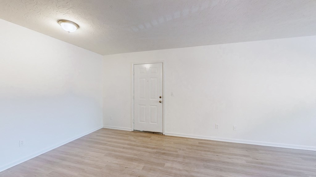 a living room with white walls and a white door