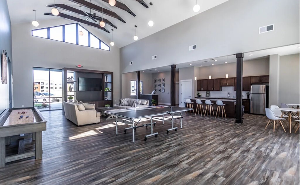 A spacious room with a pool table and a bar area.