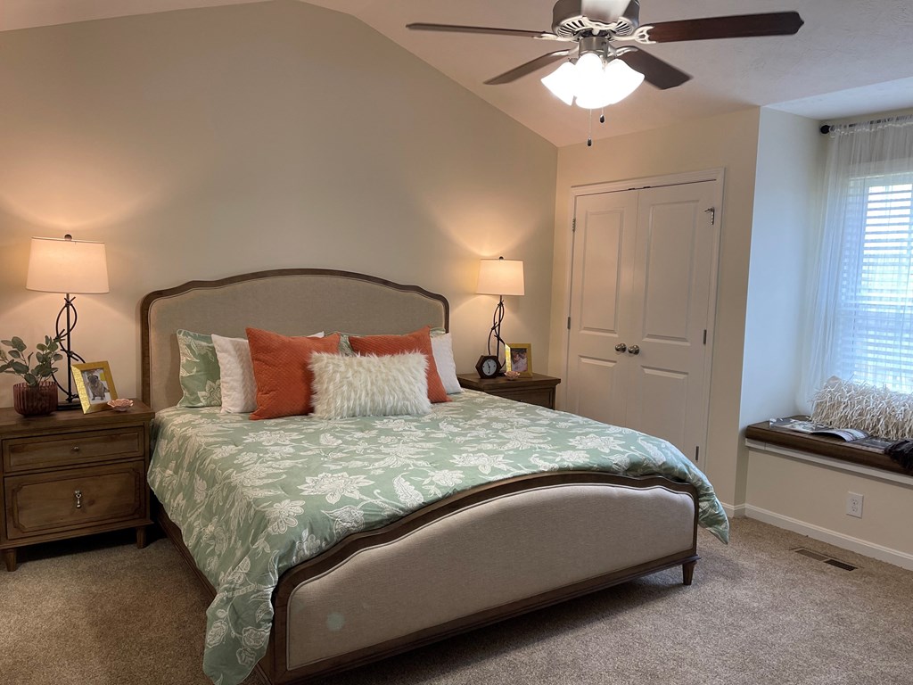 a bedroom with a bed and a ceiling fan