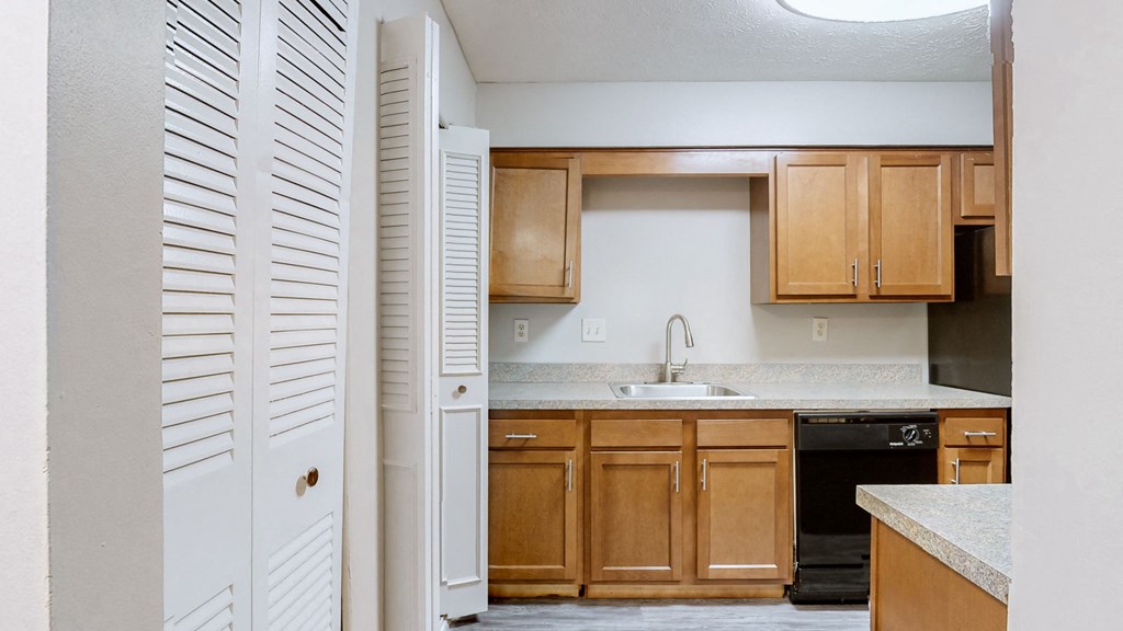 an empty kitchen with wooden cabinets and a sink