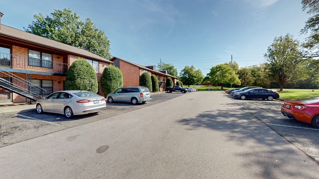 a parking lot with cars parked in front of a building