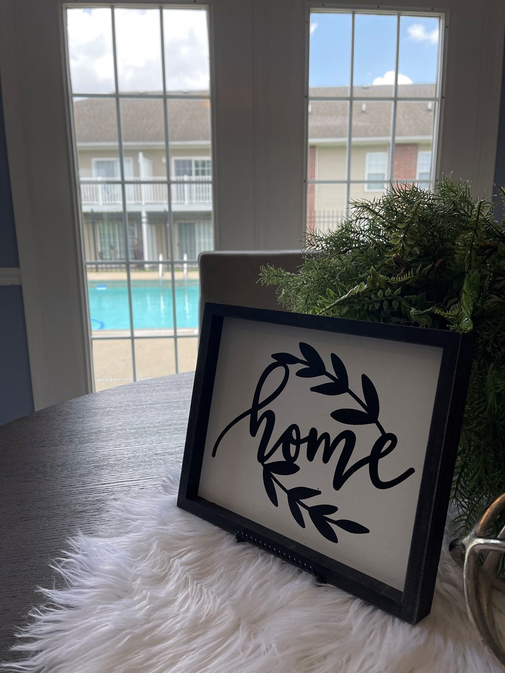 a sign that reads home on a table with a christmas tree