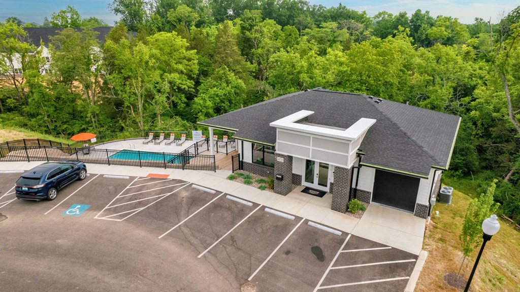 a house with a swimming pool and a parking lot