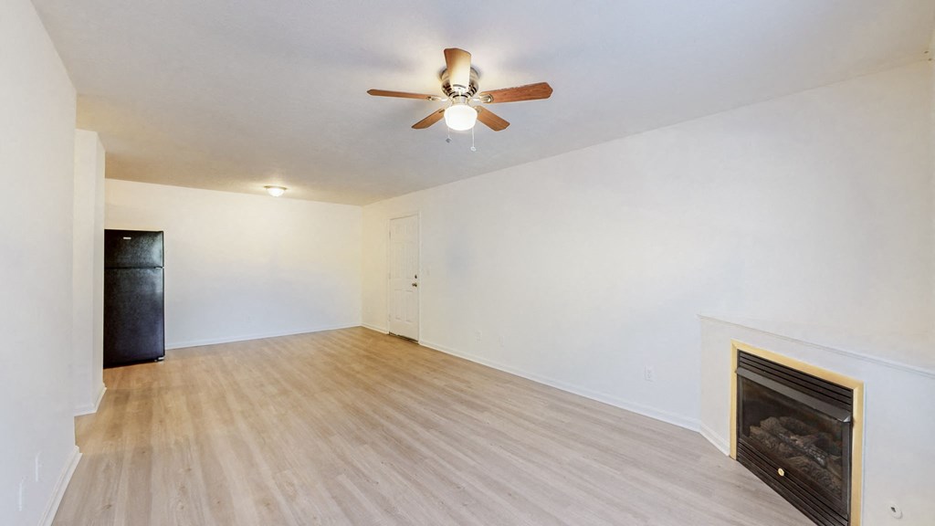 a living room with a fireplace and a ceiling fan
