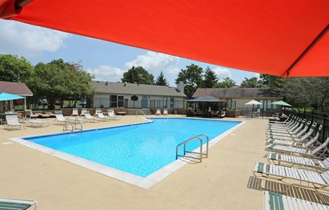 A large outdoor swimming pool with lounge chairs and umbrellas.