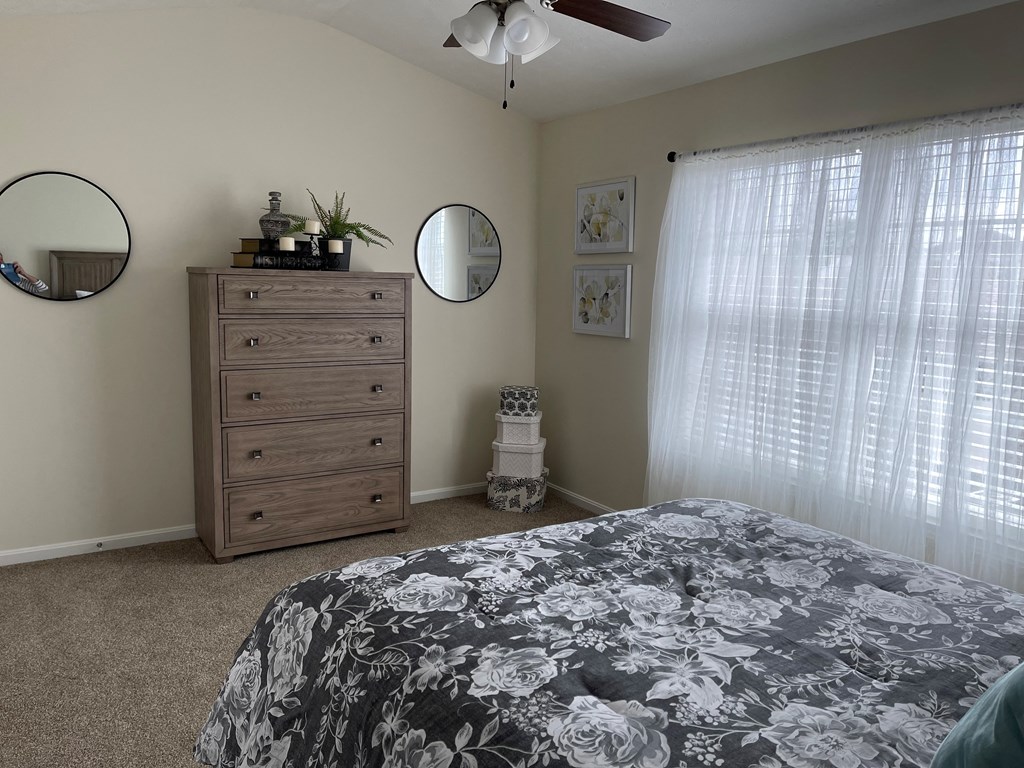 a bedroom with a bed and a dresser and a window
