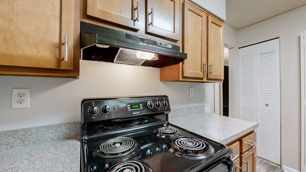 a kitchen with wood cabinets and a stove top oven