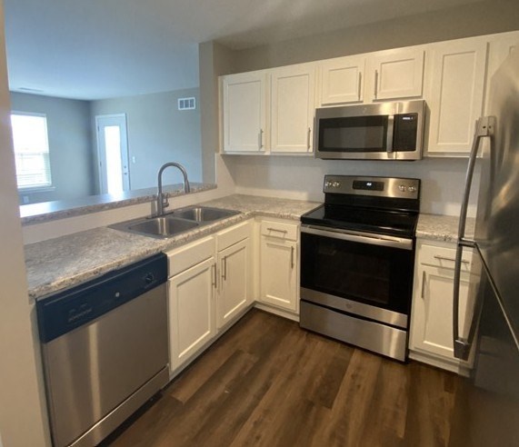 A kitchen with white cabinets and stainless steel appliances.