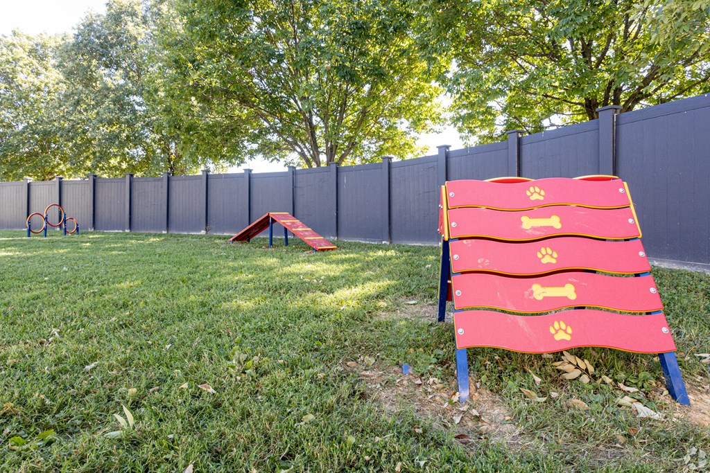 a playground with a red chair and a black fence
