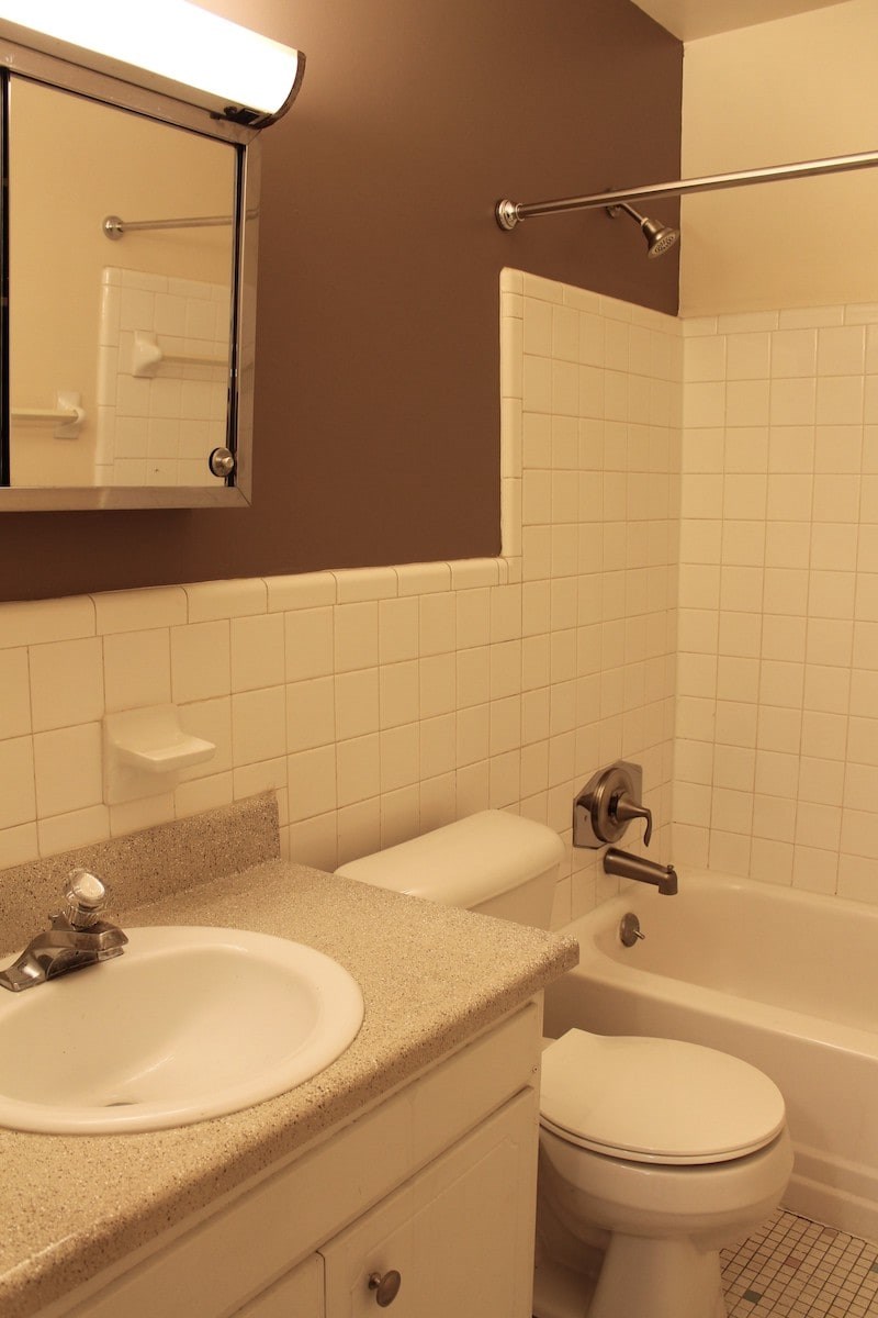 A white toilet sits next to a sink in a bathroom.