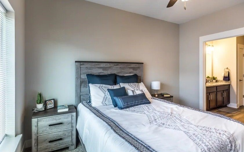A bedroom with a large bed and a ceiling fan.